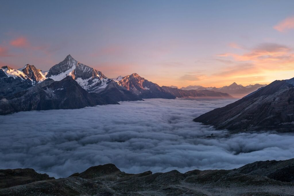 Mountain peaks above a sea of clouds at sunrise