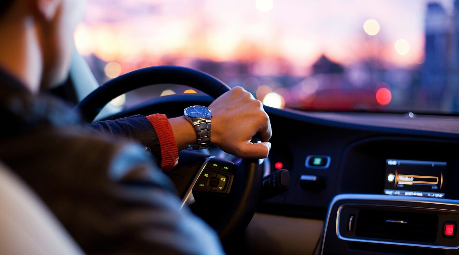 Driver with hands on the steering wheel of a rental car